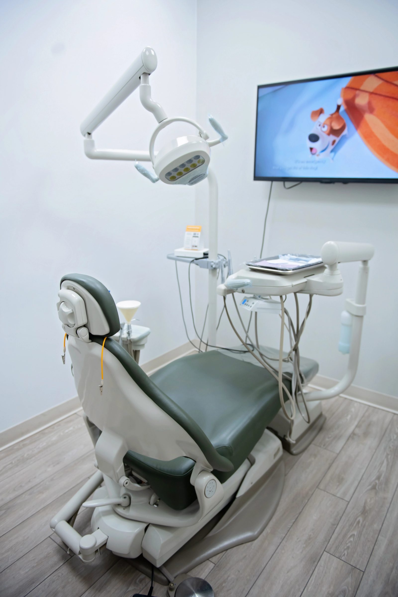 a dental office with a dental chair and a flat screen tv