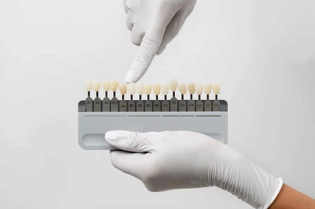 a dentist is holding a tooth color chart in his hand .